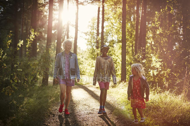 Family walking in forest at sunset — Stockfoto