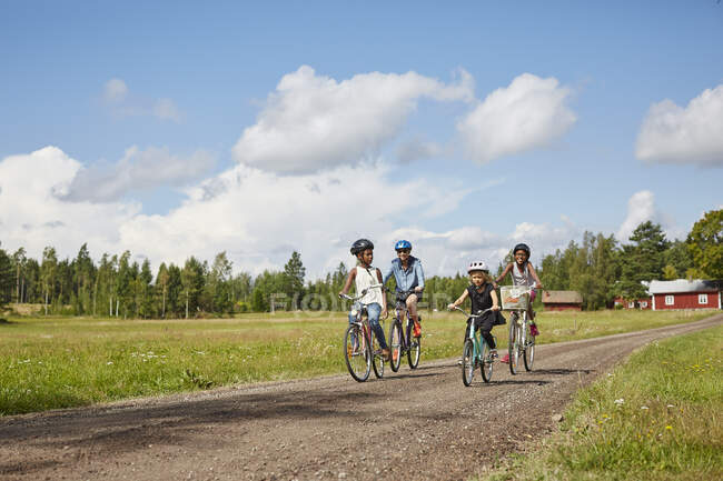 Family cycling on rural road — Photo de stock