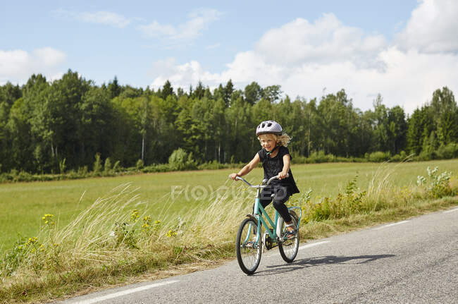 Дівчина їде на велосипеді на дорозі — стокове фото