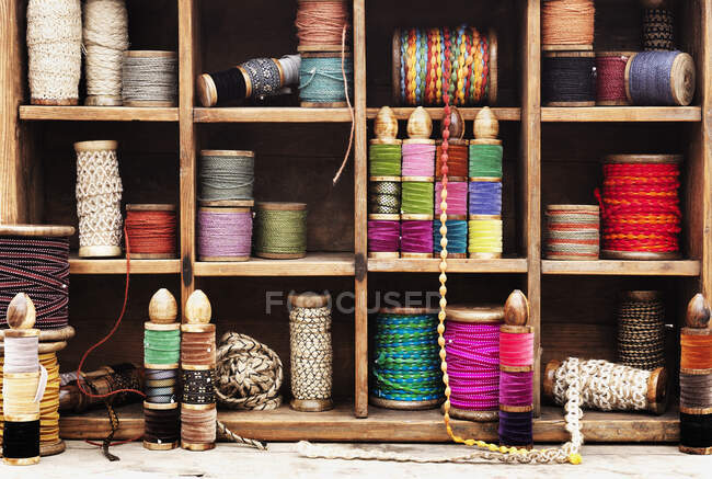 Spools of thread and ribbon on shelves — Stock Photo
