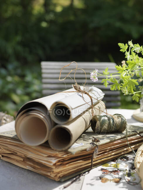 Scrolls and book on table outdoors — Stock Photo