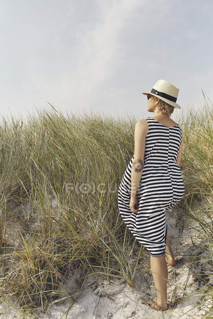 Woman in striped dress on sand dunes — Stockfoto