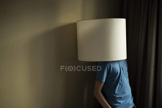Teenage boy under lampshade — Stock Photo