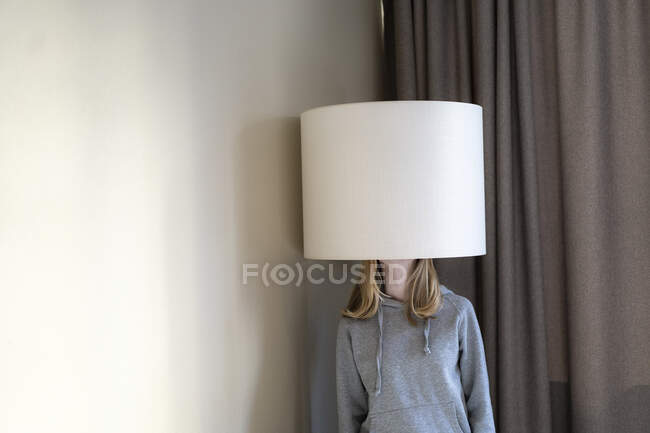 Teenage girl under lampshade - foto de stock