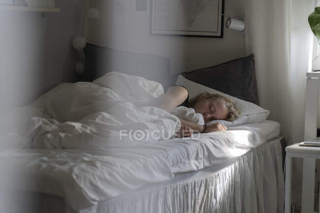 Teenage girl sleeping in bed - foto de stock