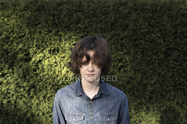 Teenage boy by hedge — Photo de stock