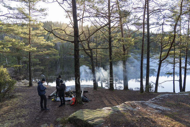 Family camping by lake — Stock Photo