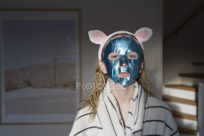 Подросток в маске для лица с повязкой на голове — стоковое фото