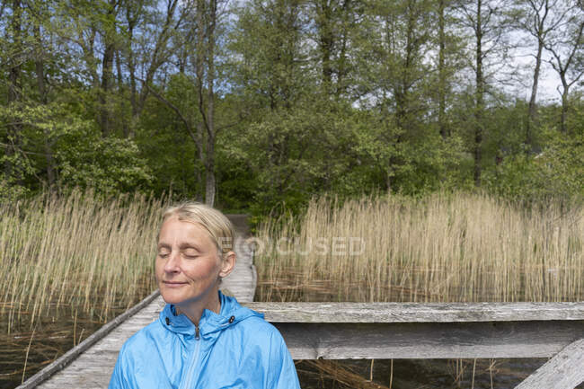 Donna in riva al lago in estate — Foto stock