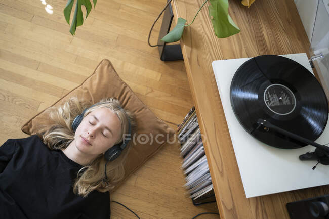 Teenage girl listening to music on record player — Stockfoto