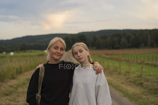 Portrait of mother and daughter on rural road - foto de stock