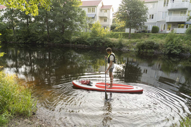 Молодий чоловік веслує на озері — стокове фото