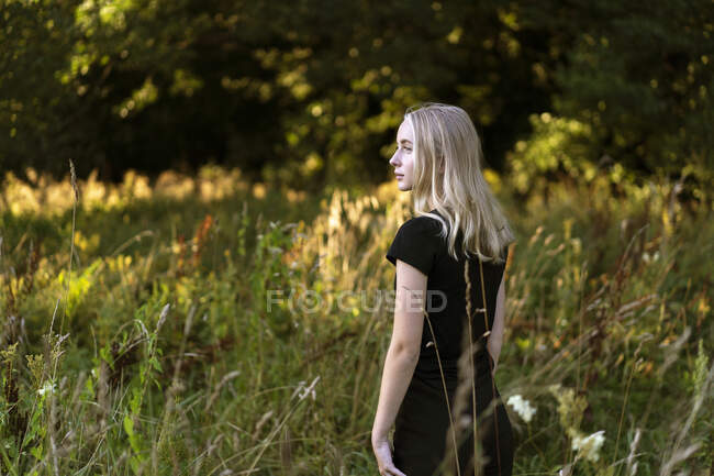 Teenage girl standing in field — Stockfoto