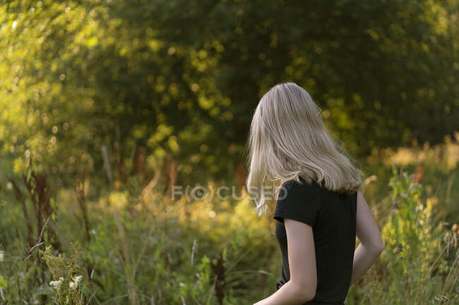 Teenage girl walking in field — Stockfoto