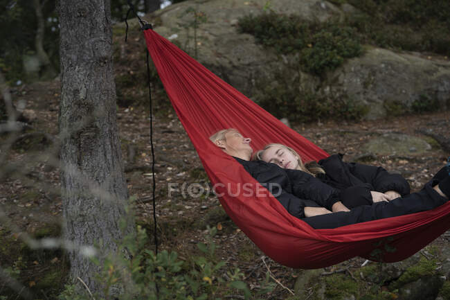 Mother and daughter lying in hammock — Stockfoto