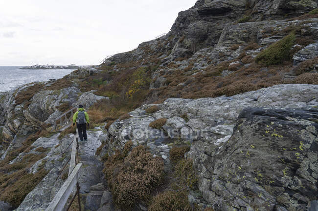 Woman hiking on rocks by sea — Stock Photo