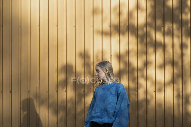 Adolescente na sombra pela parede — Fotografia de Stock