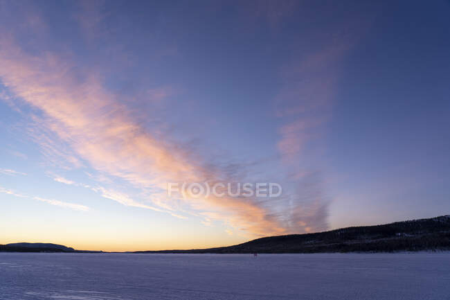 Campo nevado sob o céu por do sol — Fotografia de Stock