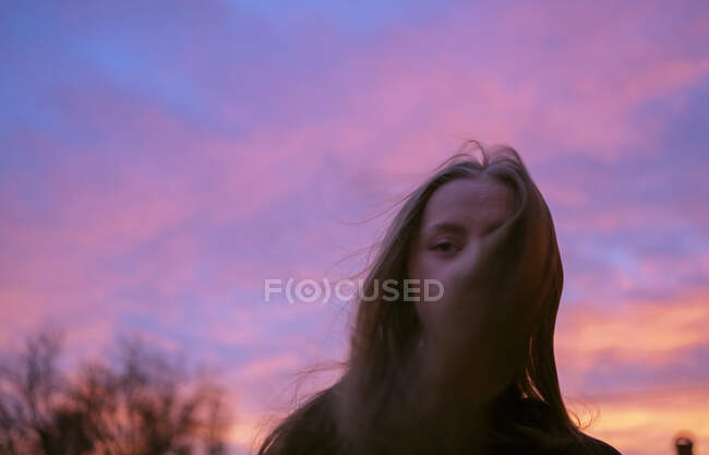 Adolescente chica bajo la puesta del sol cielo - foto de stock
