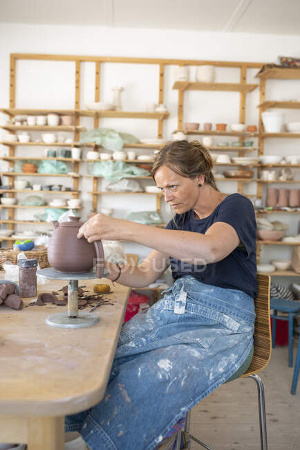 Potter making teapot in workshop — Stock Photo