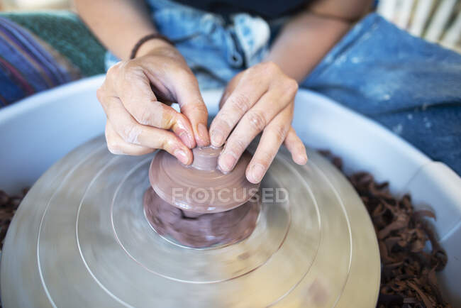 Hands of potter using pottery wheel — Stock Photo