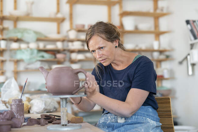 Potter making teapot in workshop — Photo de stock