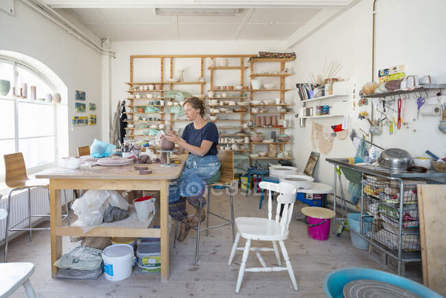 Potter working at table in workshop — Fotografia de Stock