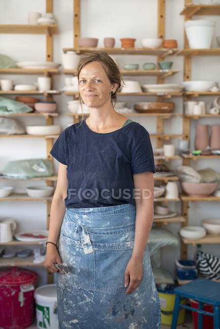 Potter wearing dirty apron in workshop — Stockfoto
