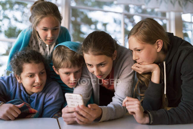 Девушка-подросток делится смартфоном — стоковое фото