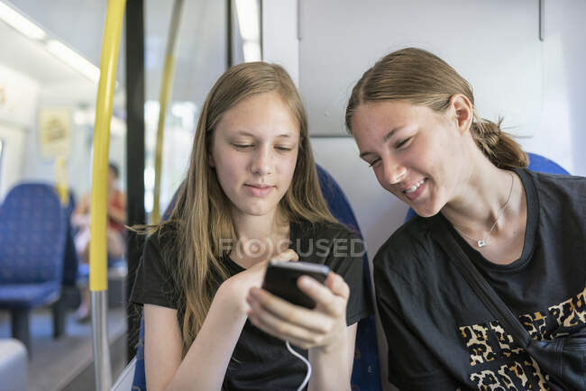Sisters commuting on train - foto de stock