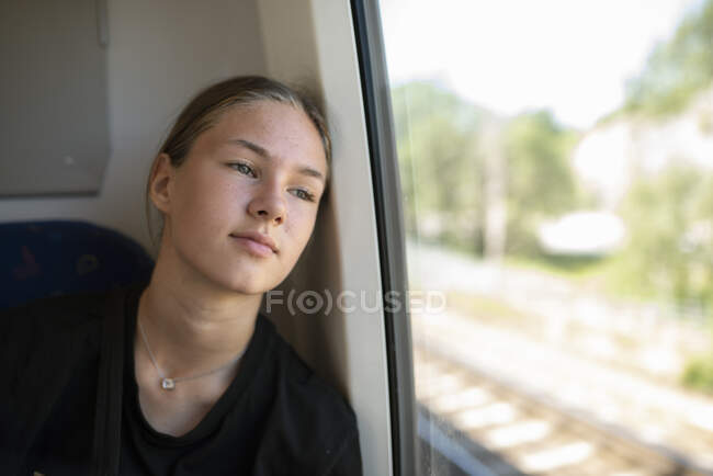Teenage girl by window on train — Foto stock