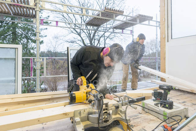 Carpenters cutting wood in house - foto de stock
