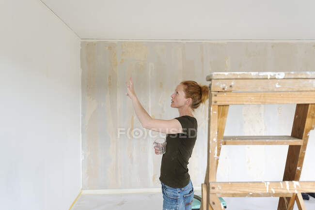 Mujer mirando a la pared en casa - foto de stock