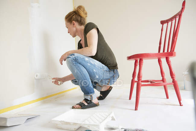 Mulher parede de pintura em casa — Fotografia de Stock