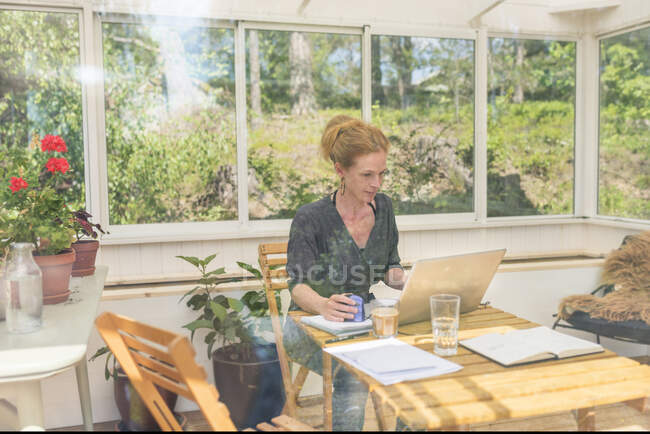 Mujer trabajando desde casa en la terraza - foto de stock