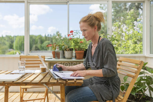 Woman working from home in sunroom — Stock Photo