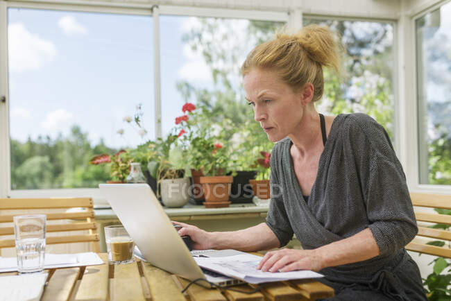 Woman working from home in sunroom — Photo de stock