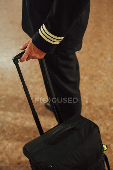 Pilote marchant avec bagages à l'aéroport — Photo de stock