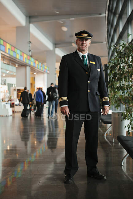 Пилот в аэропорту смотрит в камеру — стоковое фото