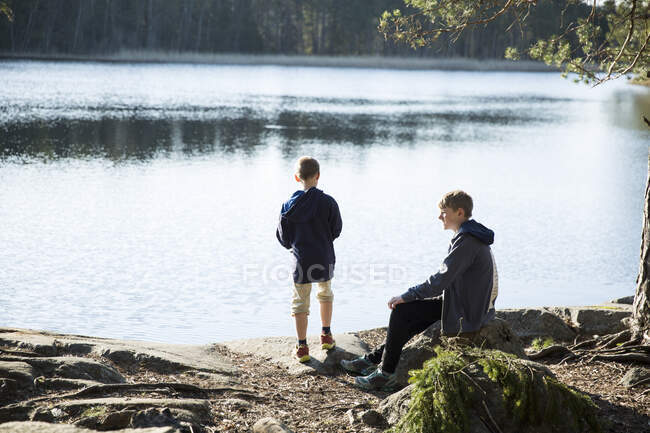 Hermanos junto al lago Trehorningen en la Reserva Natural de Domarudden, Suecia - foto de stock