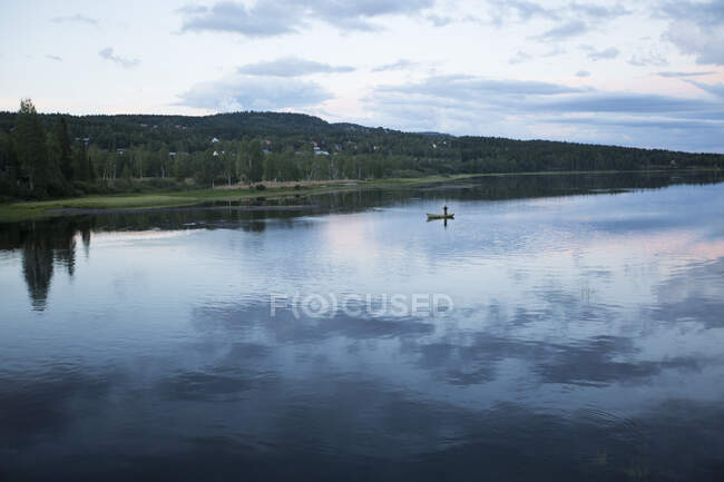 Man in rowboat on Indalsalven River at sunset in Undersaker, Sweden — Stock Photo