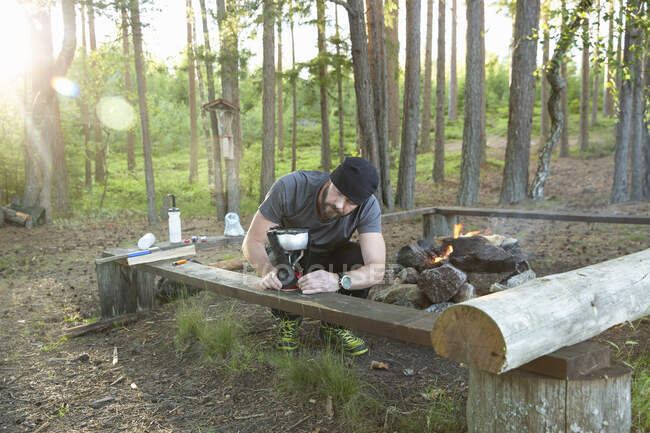Homem usando fogão de acampamento na floresta — Fotografia de Stock