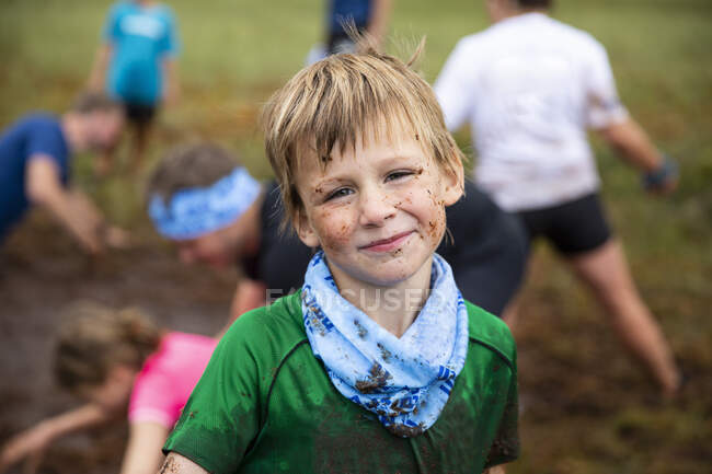 Portrait of boy with muddy face in field — Stock Photo
