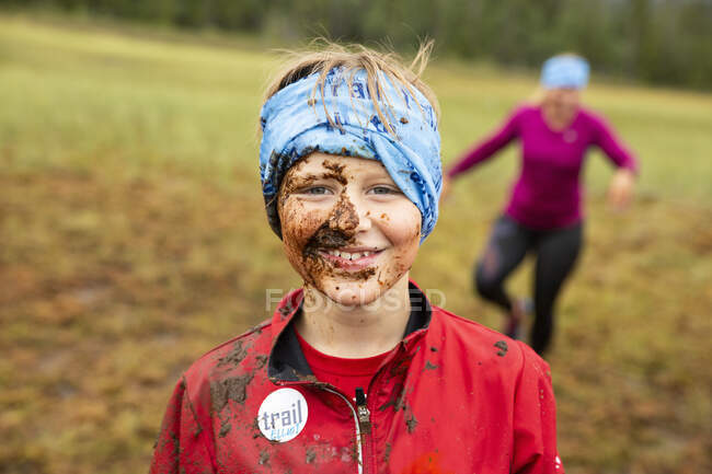 Portrait of smiling boy with muddy face in field — Fotografia de Stock