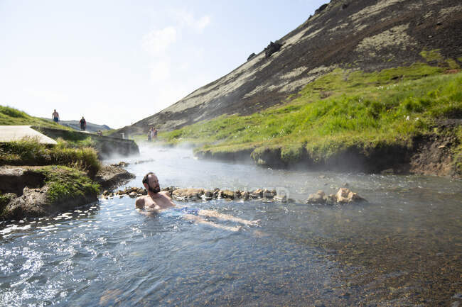 Mature man bathing in hot spring — Stock Photo