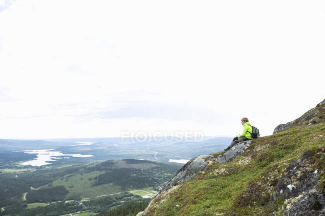 Хлопчик сидить на пагорбі — стокове фото