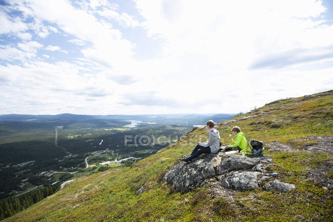 Boys eating lunch on hill — Stock Photo