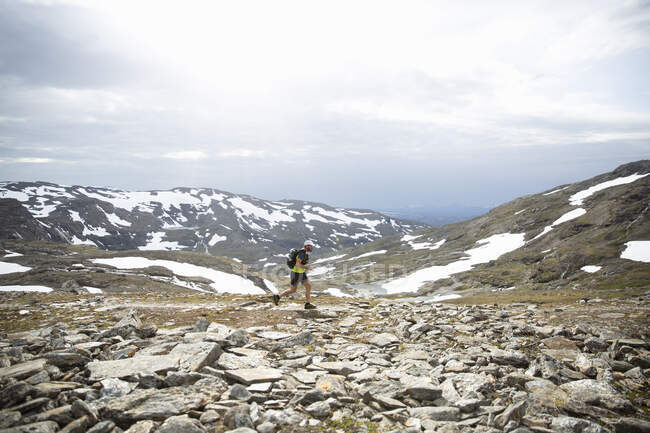 Uomo maturo che fa jogging in montagna — Foto stock
