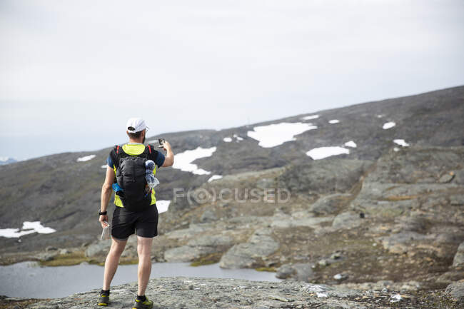Maduro homem usando bússola no montanha — Fotografia de Stock