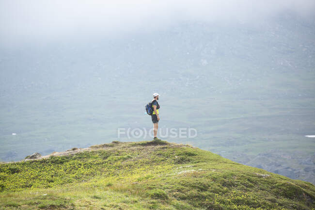 Зрелый человек, стоящий на горе — стоковое фото